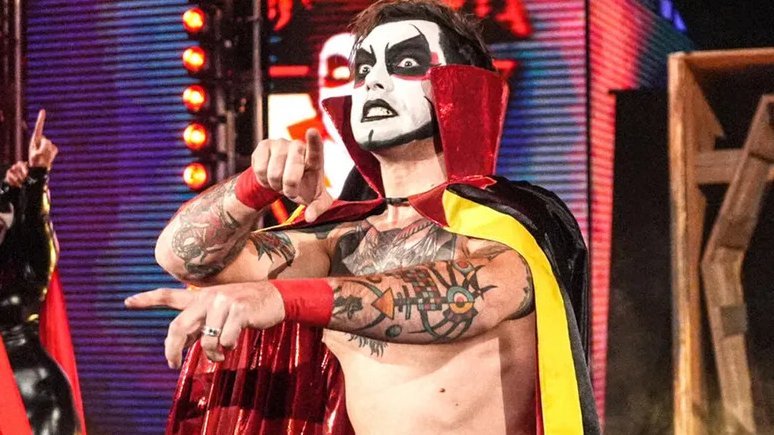 Danhausen in full character — cape, face paint, pointing at his enemies